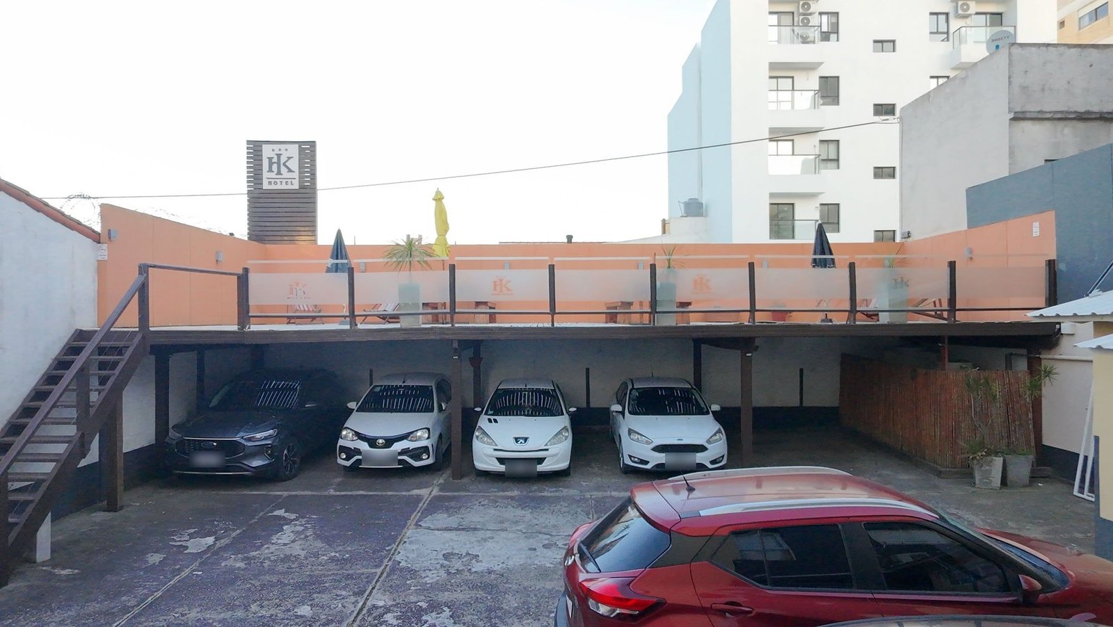 Cochera cubierta del hotel con autos estacionados debajo del solarium