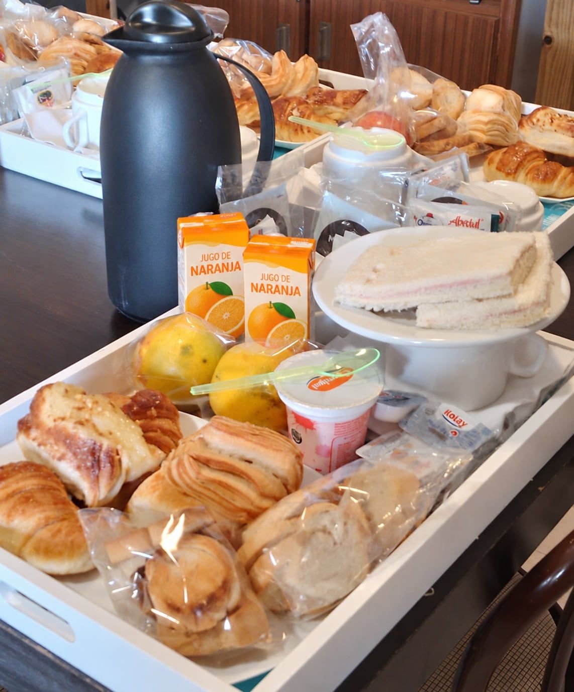 Bandejas de desayuno con medialunas, sándwiches de miga, jugo de naranja, fruta y yogur