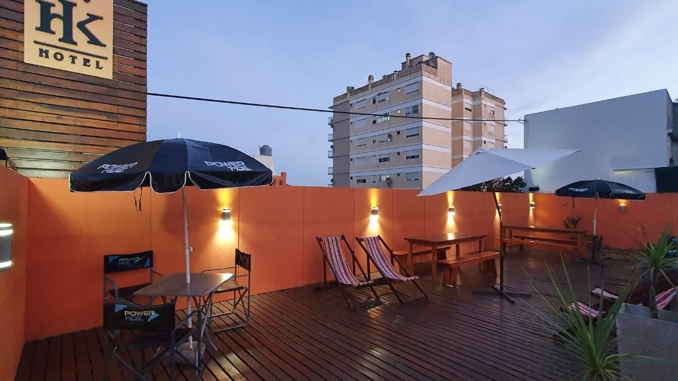 Solarium del hotel al atardecer con reposeras y mesas